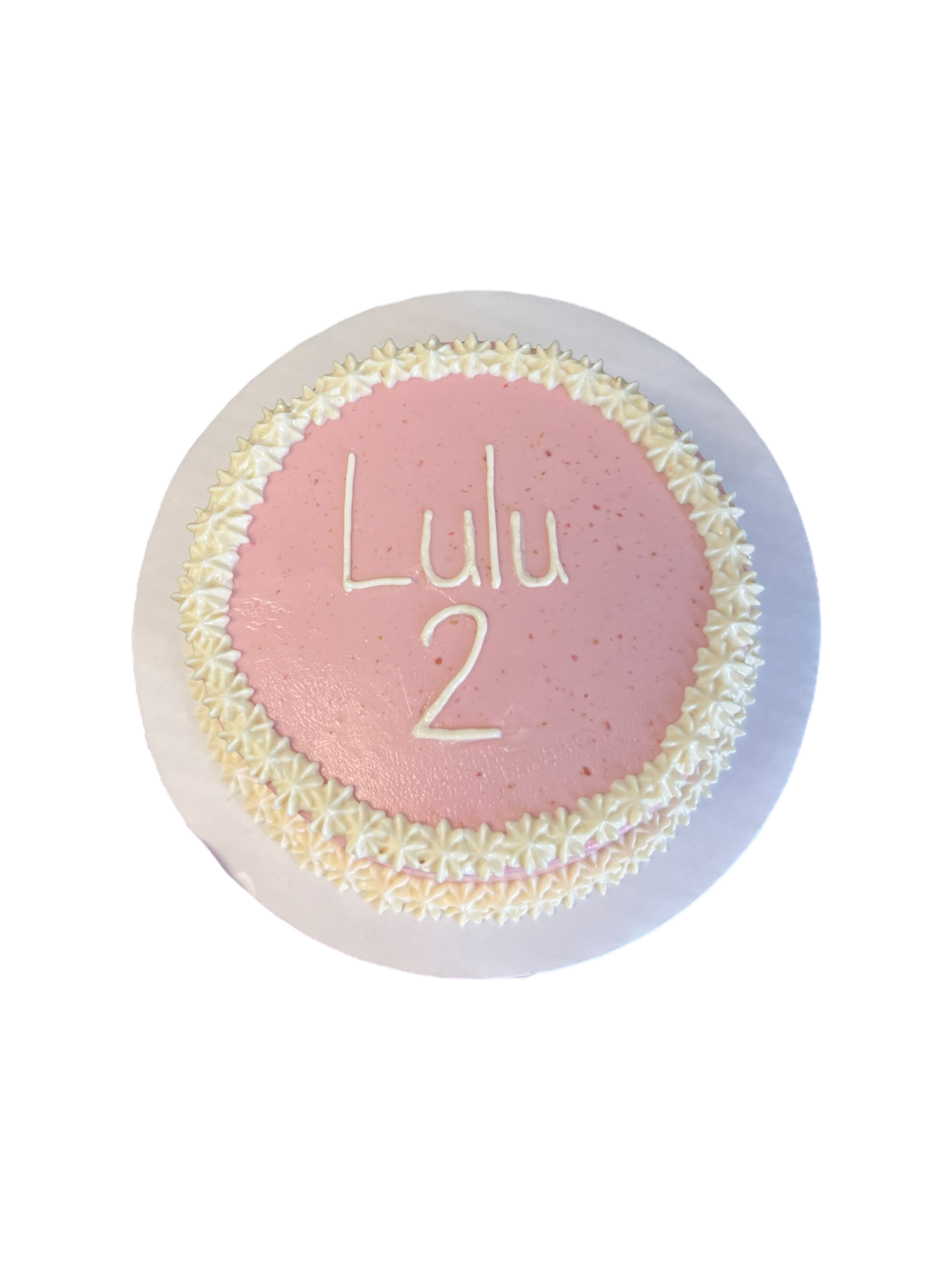 Circle dog birthday cake decorated with pink icing and white flower accents for pet celebrations