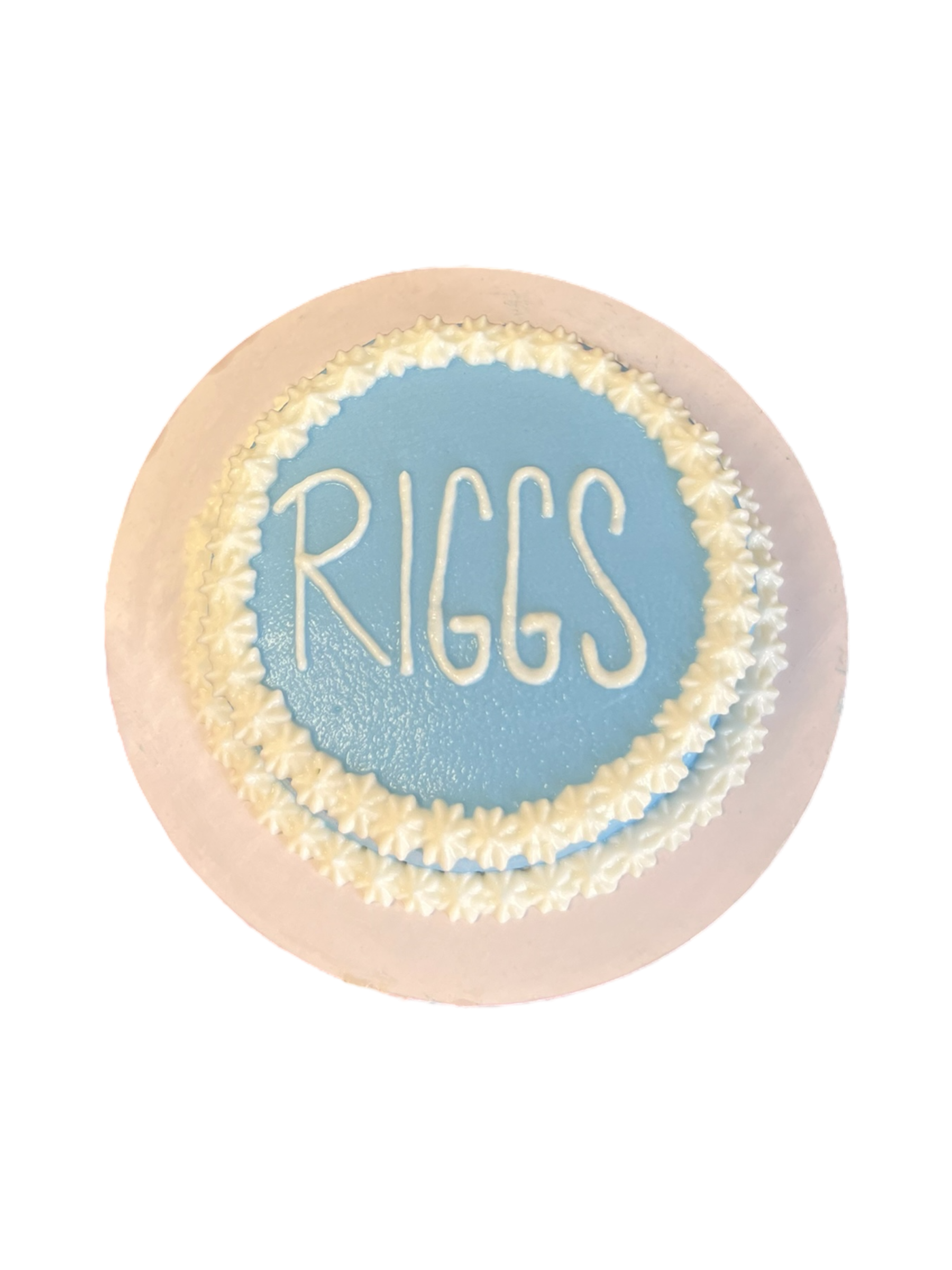 Circle dog birthday cake customized with blue frosting and the name Riggs on top
