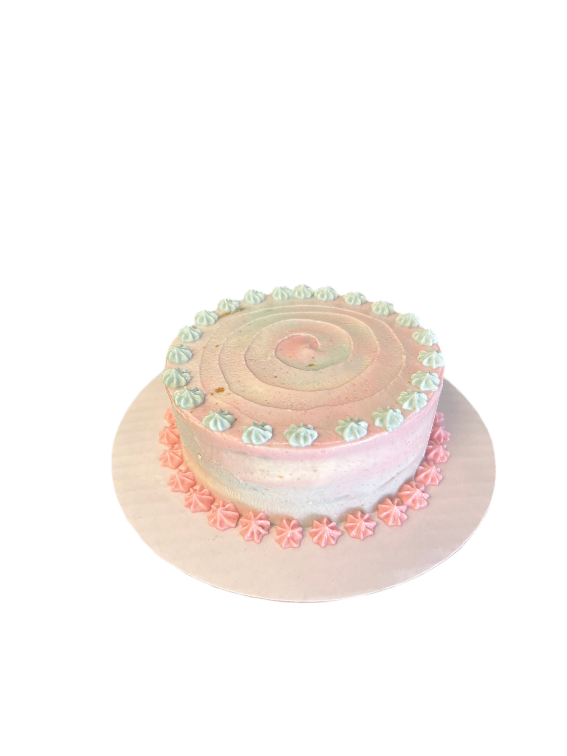 The Barkery LLC gender reveal dog cake with pink and blue frosting swirls and decorative icing accents
