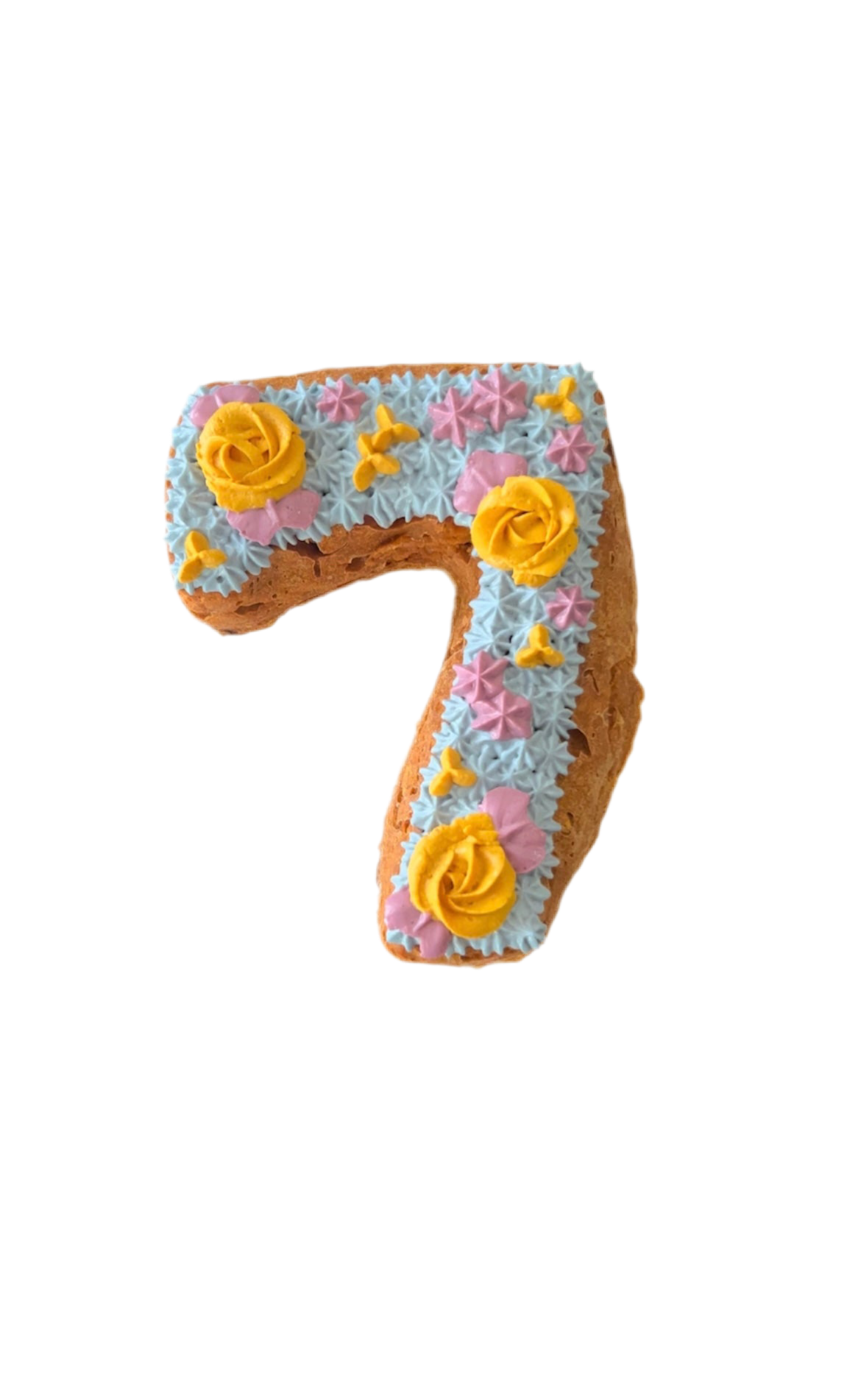 Organic dog birthday cake shaped like number seven with colorful frosting and decorative flowers