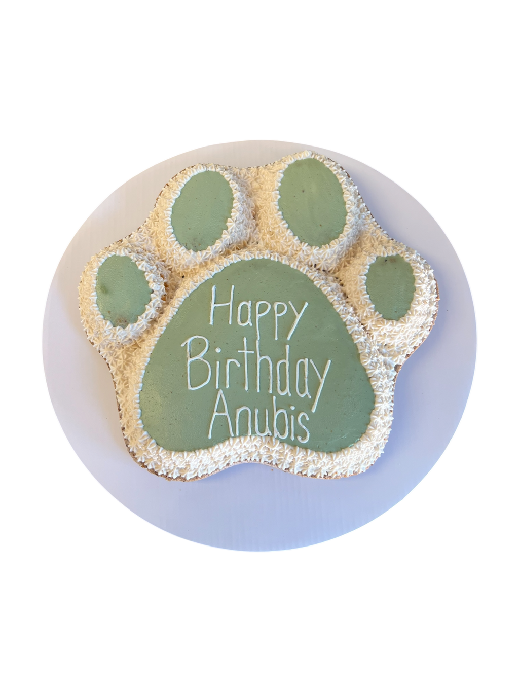 Paw print dog cake designed for celebrations, featuring 'Happy Birthday Anubis' text on a green paw shape