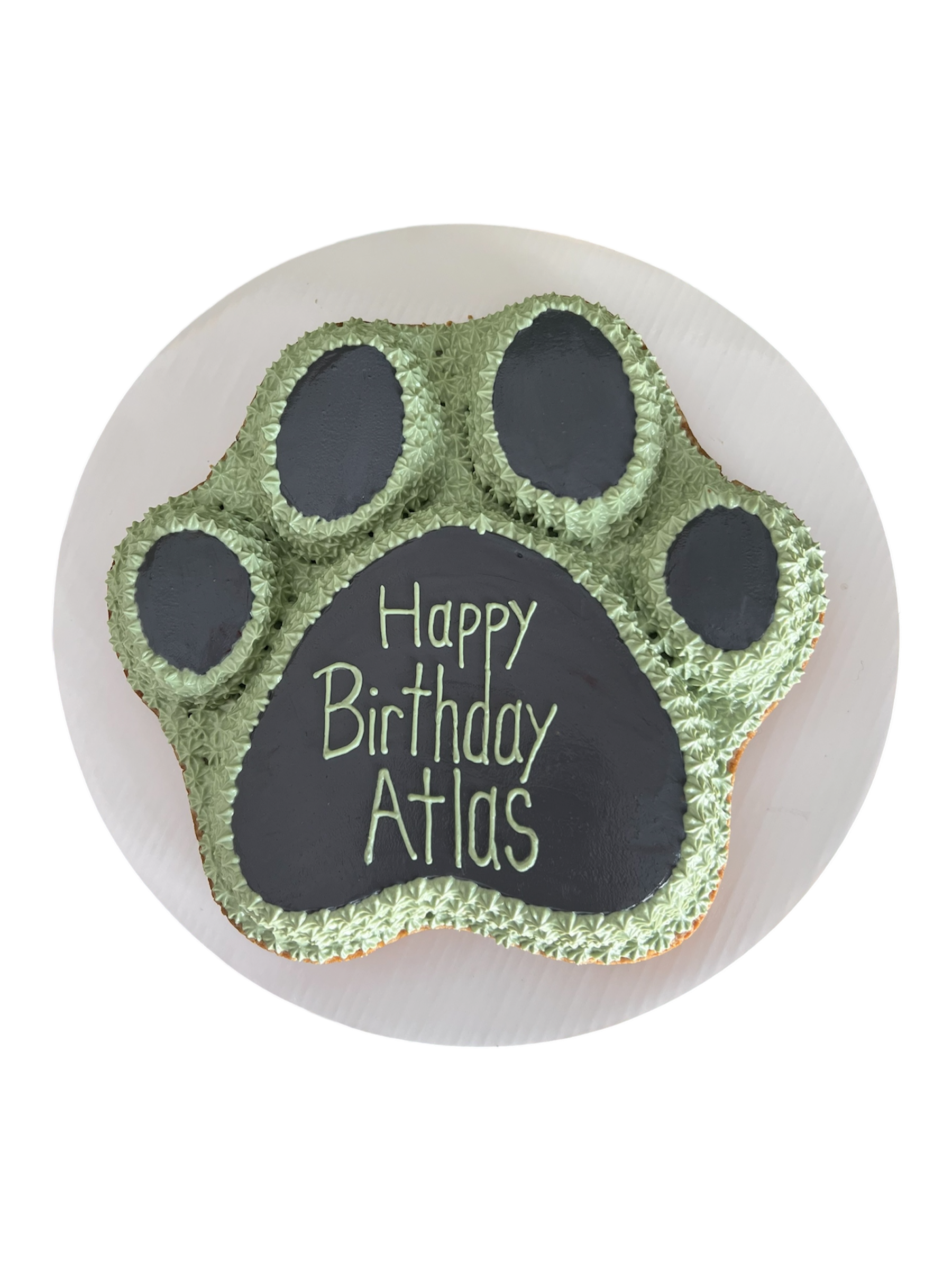 Paw print dog cake from The Barkery LLC, decorated for a birthday celebration with green accents
