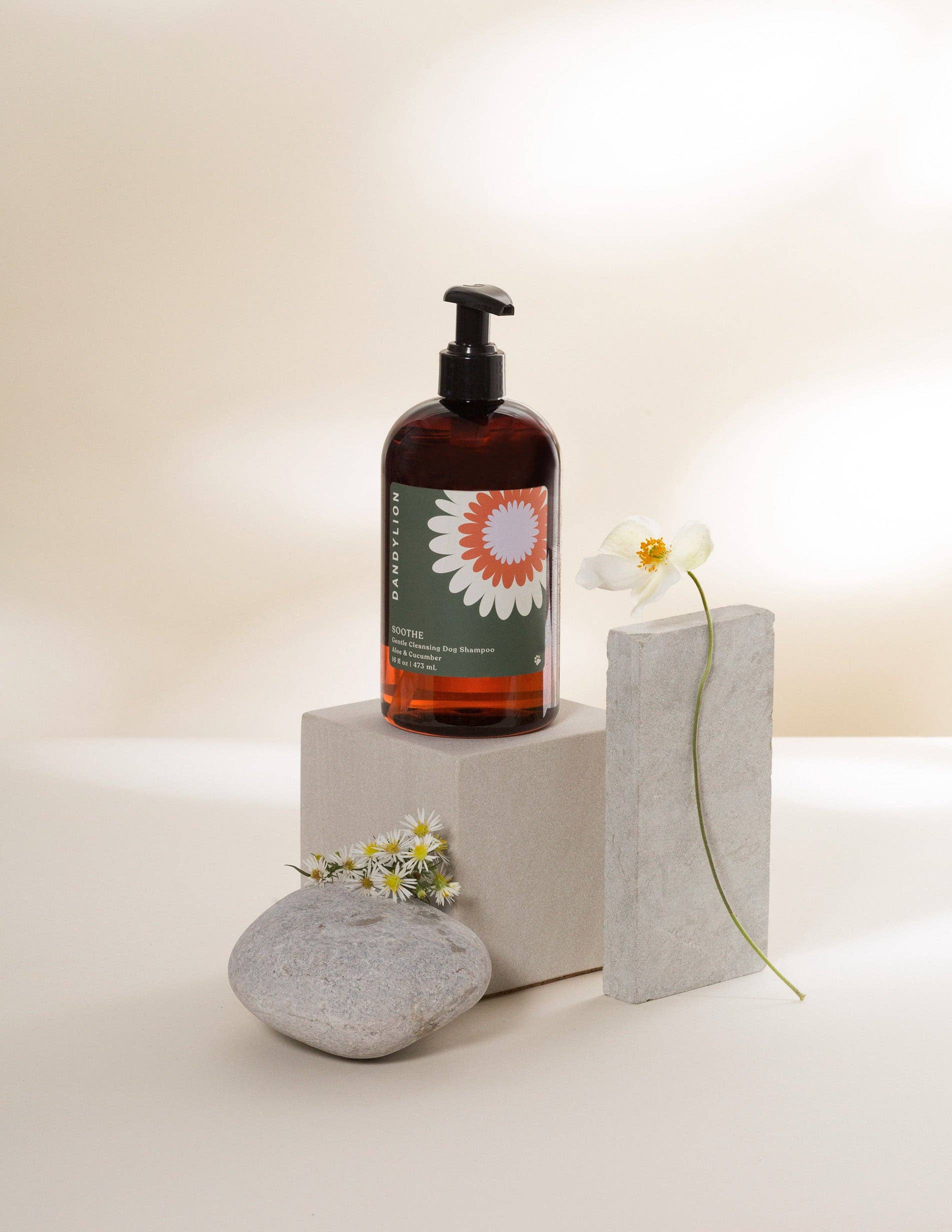 Gentle dog shampoo by Dandylionworld in a stylish bottle displayed with natural stones and flowers